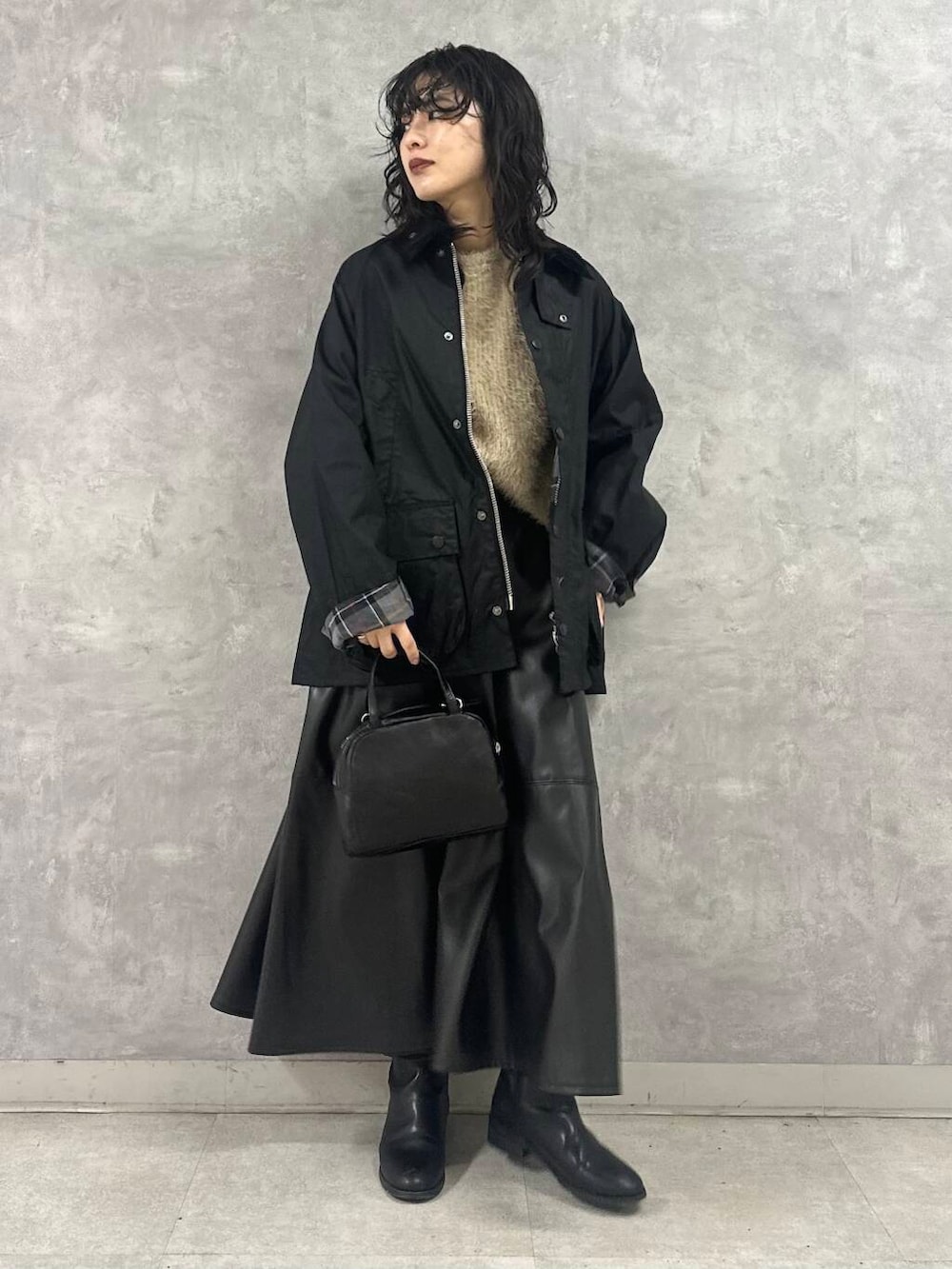 ブラック系のその他アウター、ブラック系のショルダーバッグ、ブラック系のスカートを着用したレディースの冬コーディネートの4枚目の写真