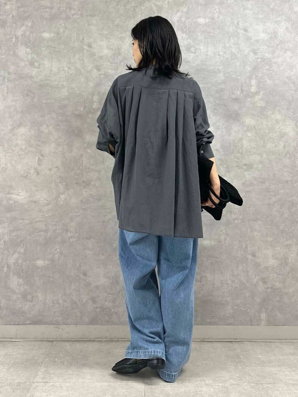 ブラック系のサンダル、ブルー系のデニムパンツ、ブラック系のトートバッグを着用したレディースの夏コーディネートの4枚目の写真