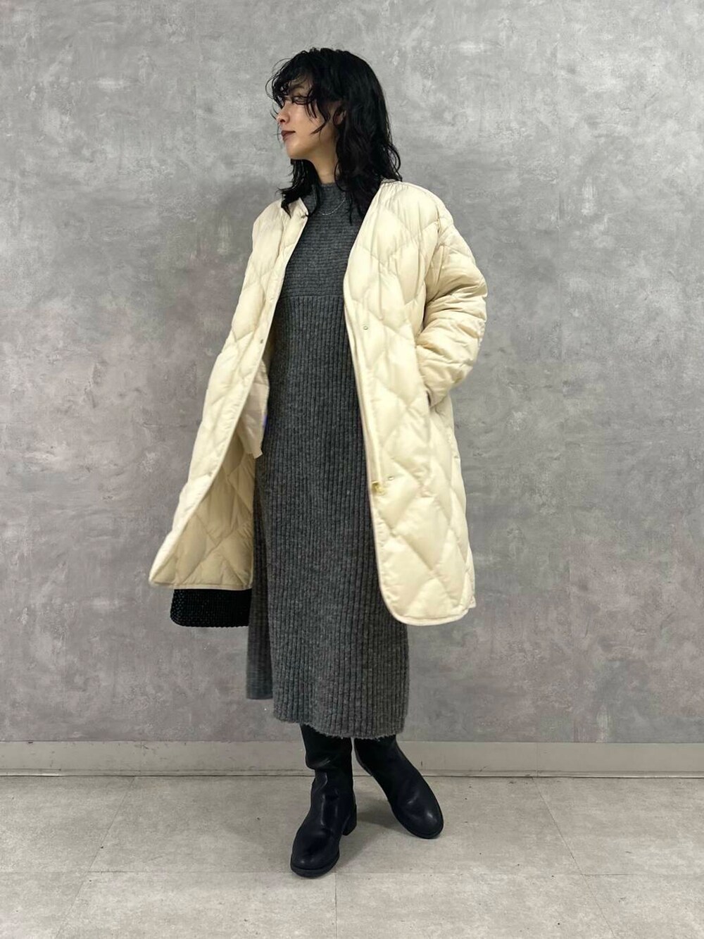 ホワイト系のダウンジャケット/コート、グレー系のワンピース、ブラック系のショルダーバッグを着用したレディースの冬コーディネートの2枚目の写真