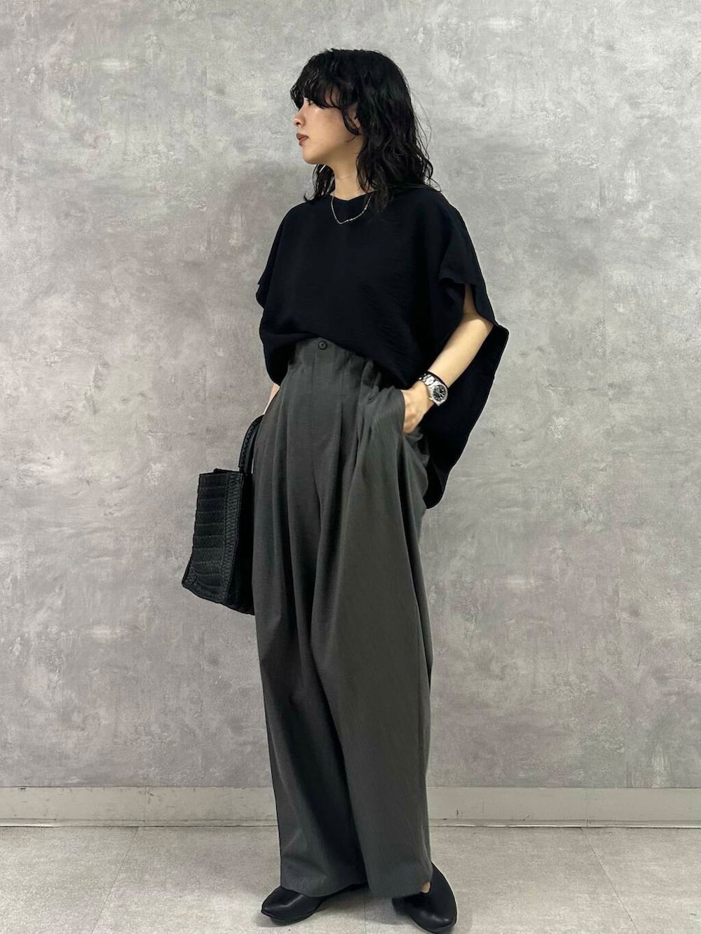 ブラック系のパンプス、ブラック系のハンドバッグ、ブルー系のシャツ/ブラウスを着用したレディースの夏コーディネートの2枚目の写真