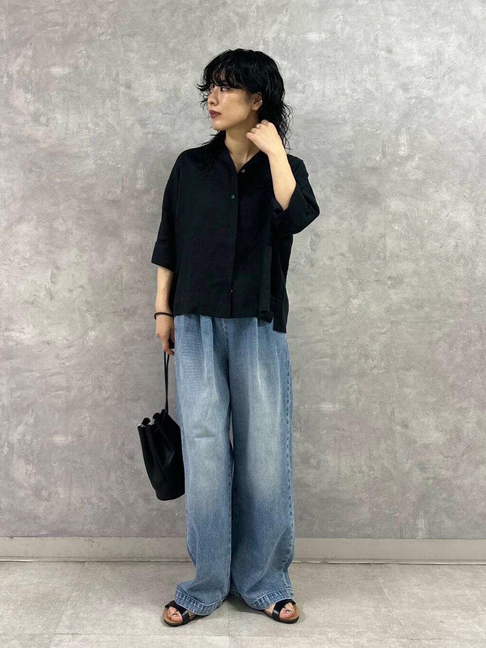 ブルー系のデニムパンツ、ブラック系のシャツ/ブラウス、ブラック系のサンダルを着用したレディースの夏コーディネートの2枚目の写真