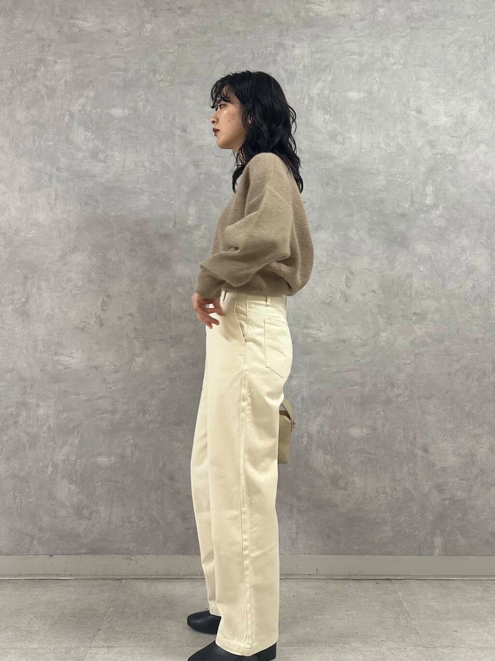 ブラック系のブーツ、ホワイト系のダウンジャケット/コート、ベージュ系のデニムパンツを着用したレディースの冬コーディネートの4枚目の写真