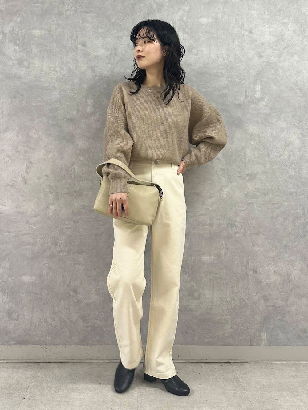 ブラック系のブーツ、ホワイト系のダウンジャケット/コート、ベージュ系のデニムパンツを着用したレディースの冬コーディネートの2枚目の写真