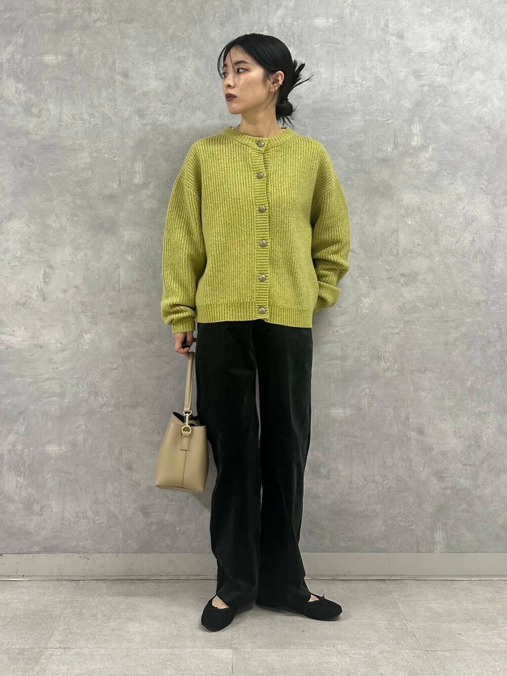 ブラック系のバレエシューズ、グリーン系のカーディガン/ボレロ、ベージュ系のショルダーバッグを着用したレディースの秋コーディネートの3枚目の写真