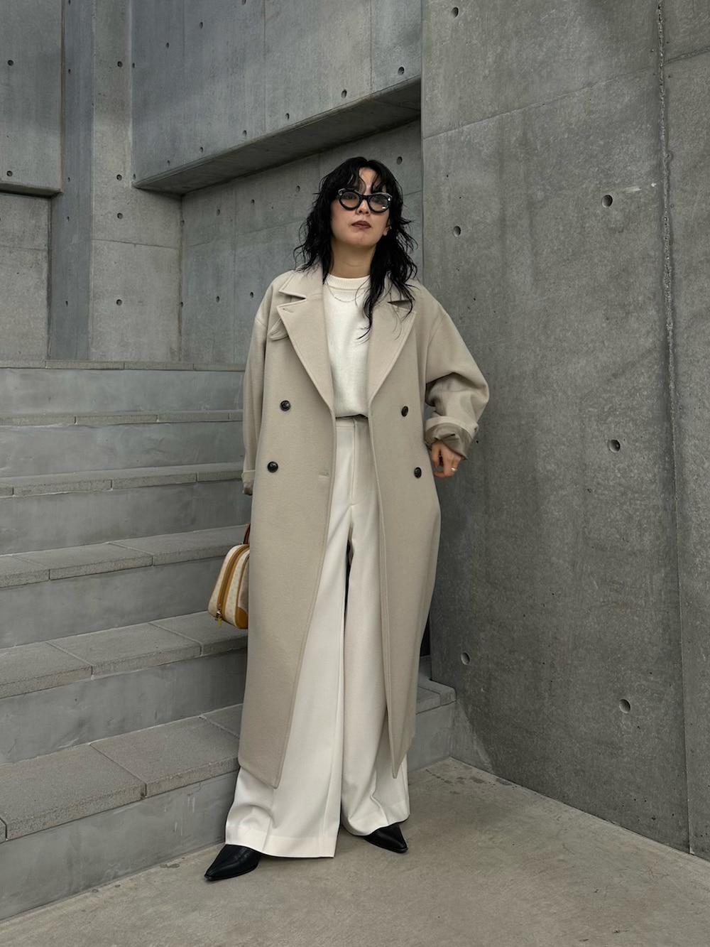 ベージュ系のチェスターコート、ホワイト系のその他パンツ、ホワイト系のニット/セーターを着用したレディースの冬コーディネートの2枚目の写真