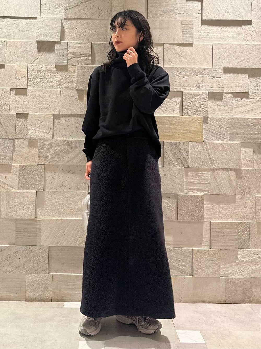 グリーン系のダウンジャケット/コート、ブラック系のスウェット、シルバー系のショルダーバッグを着用したレディースの秋コーディネートの5枚目の写真