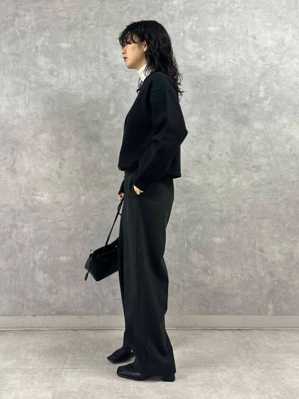 ホワイト系のTシャツ/カットソー、ブラック系のカーディガン/ボレロ、グレー系のその他パンツを着用したレディースの冬コーディネートの3枚目の写真