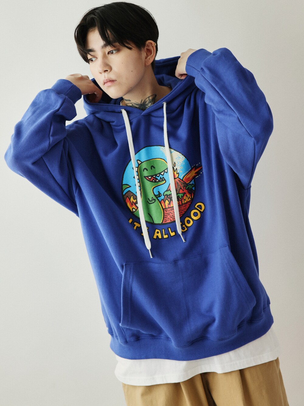 ブルー系のパーカー、ベージュ系のパンツ、ホワイト系のスニーカーを着用したレディースの秋コーディネートの2枚目の写真