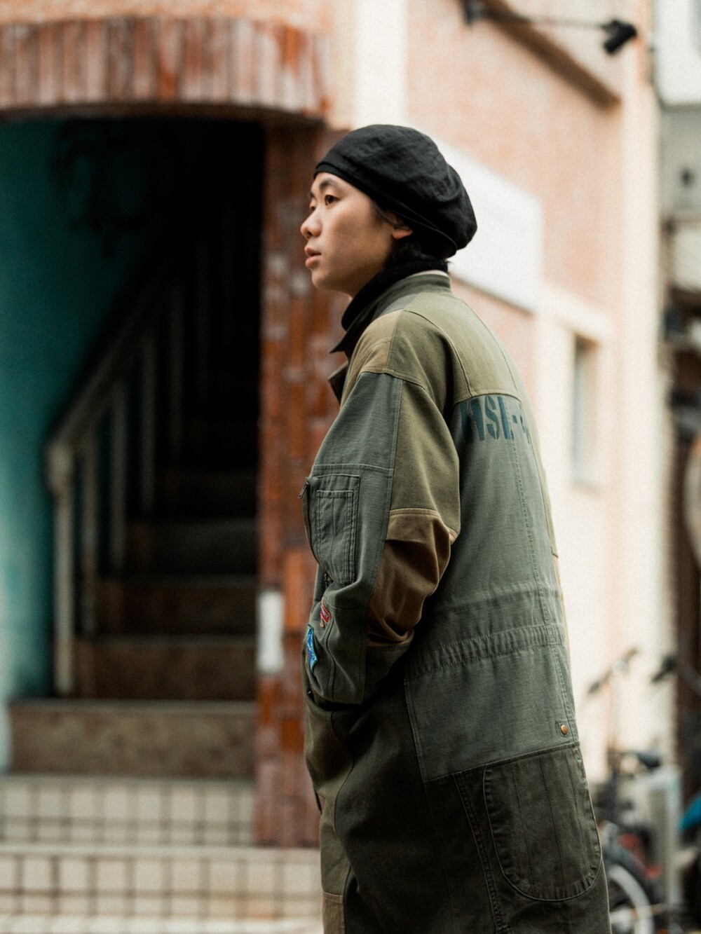 ブラック系のパンツ、グリーン系のモッズコート、ベージュ系のダウンジャケット/コートを着用したメンズの冬コーディネートの4枚目の写真