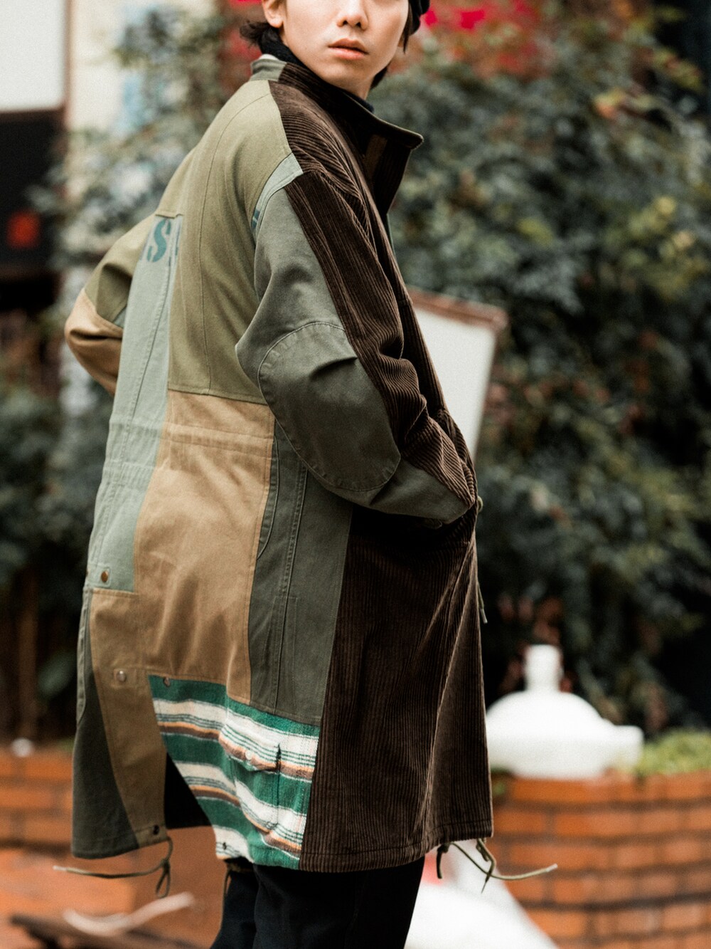 ブラック系のパンツ、グリーン系のモッズコート、ベージュ系のダウンジャケット/コートを着用したメンズの冬コーディネートの5枚目の写真