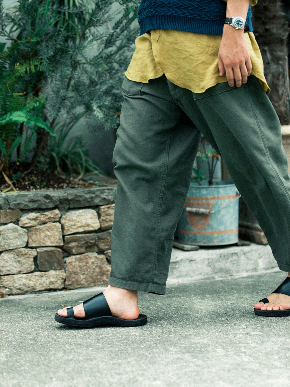 ブルー系のベスト、グリーン系のカーゴパンツ、ブラック系のサンダルを着用したメンズの夏コーディネートの5枚目の写真