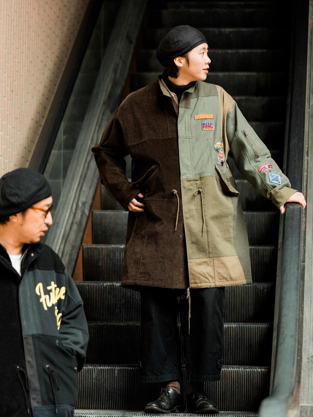 ブラック系のパンツ、グリーン系のモッズコート、ベージュ系のダウンジャケット/コートを着用したメンズの冬コーディネートの2枚目の写真