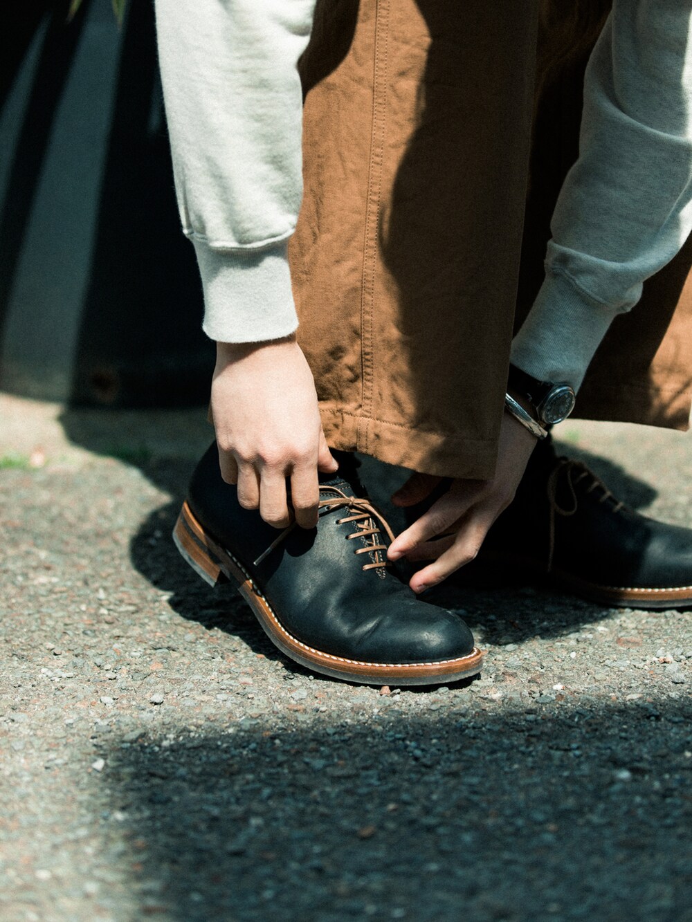 ブラウン系のチノパンツ、パープル系のカバーオール、ブラック系のドレスシューズを着用したメンズの春コーディネートの4枚目の写真