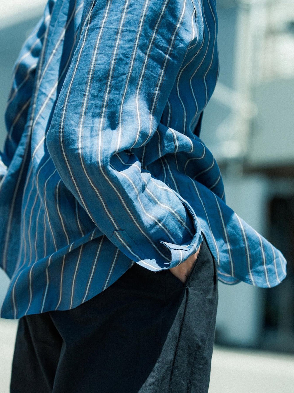 ブラック系のパンツ、ブラック系のドレスシューズ、ブルー系のシャツ/ブラウスを着用したメンズの夏コーディネートの4枚目の写真