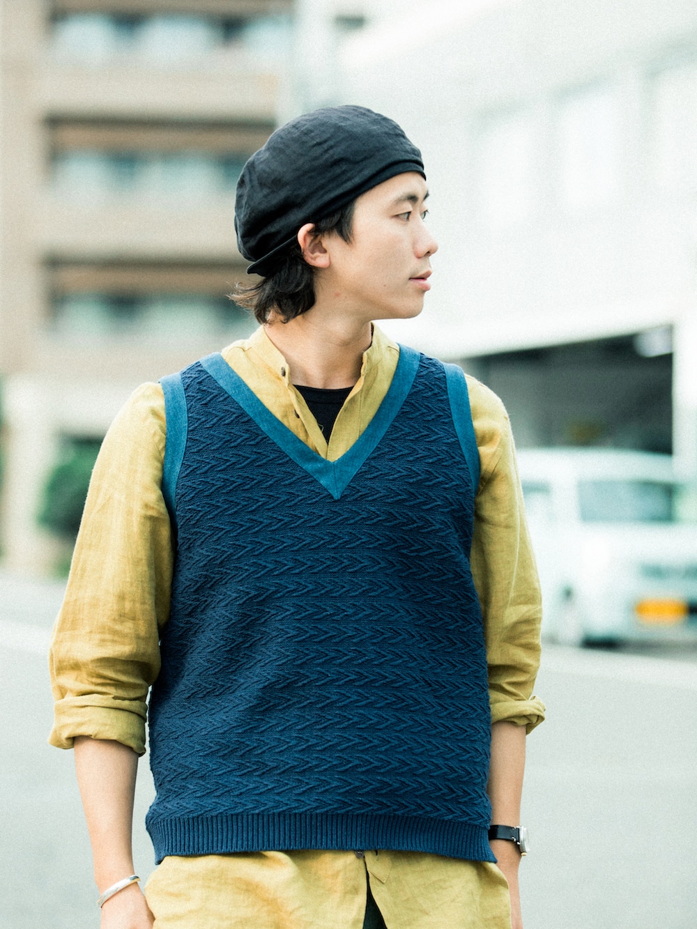 ブルー系のベスト、グリーン系のカーゴパンツ、ブラック系のサンダルを着用したメンズの夏コーディネートの2枚目の写真