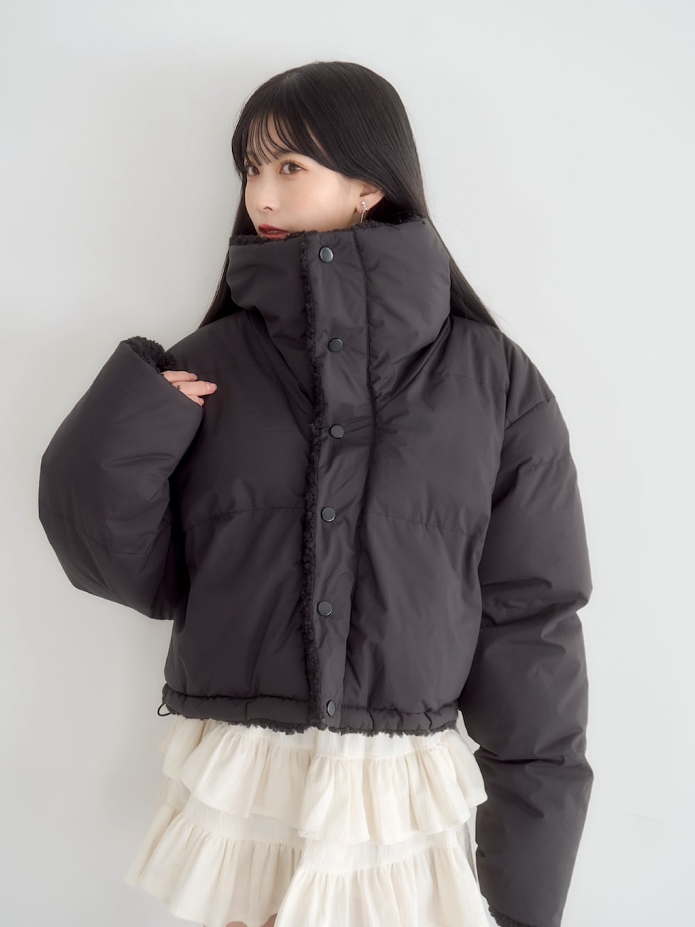 ブラック系のスウェット、ホワイト系のスカート、ブラック系のダウンジャケット/コートを着用したレディースの冬コーディネートの3枚目の写真