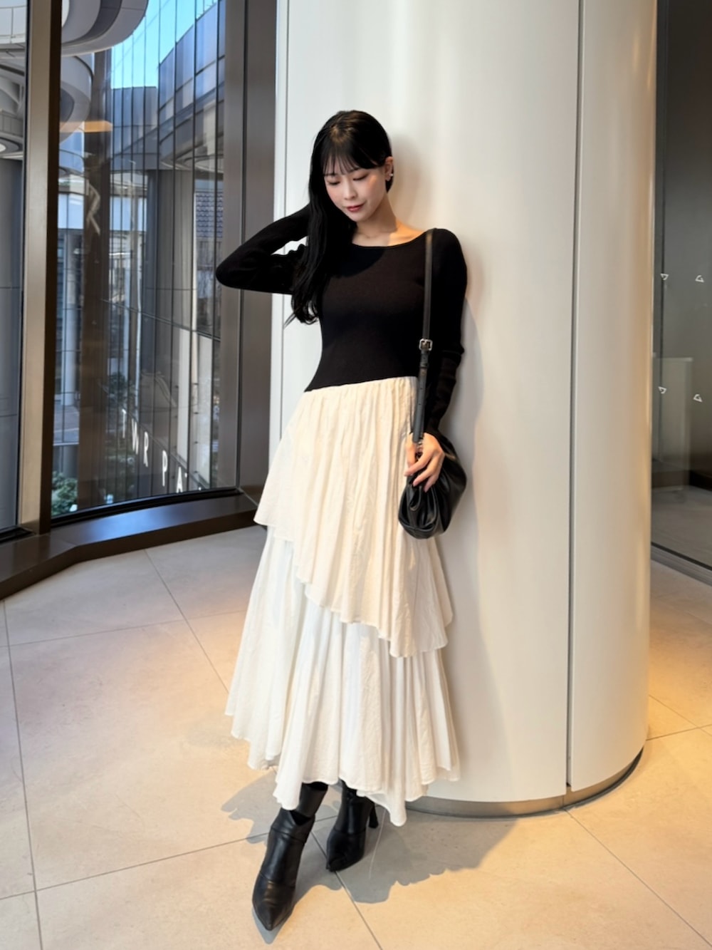 ブラック系のブーツ、ブラック系のバッグ、その他のワンピースを着用したレディースの春コーディネートの2枚目の写真