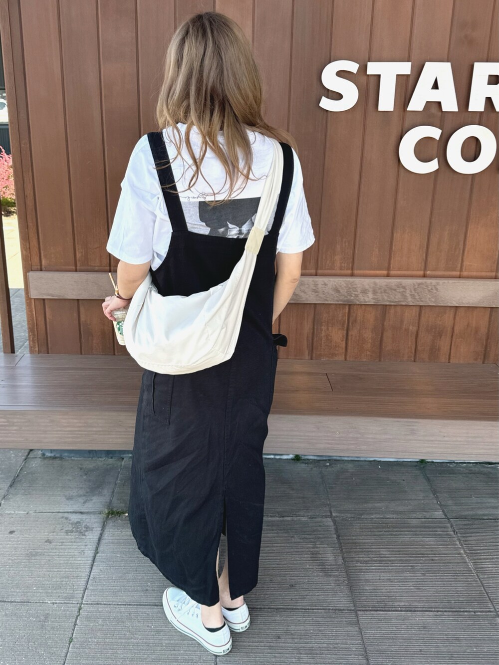 ホワイト系のTシャツ/カットソー、ブラック系のスカート、ホワイト系のスニーカーを着用したレディースの春コーディネートの3枚目の写真