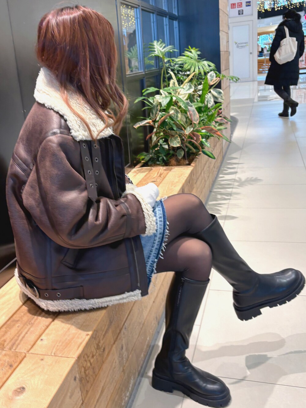 パープル系のニット/セーター、ホワイト系のTシャツ/カットソー、ブルー系のデニムスカートを着用したレディースの冬コーディネートの3枚目の写真