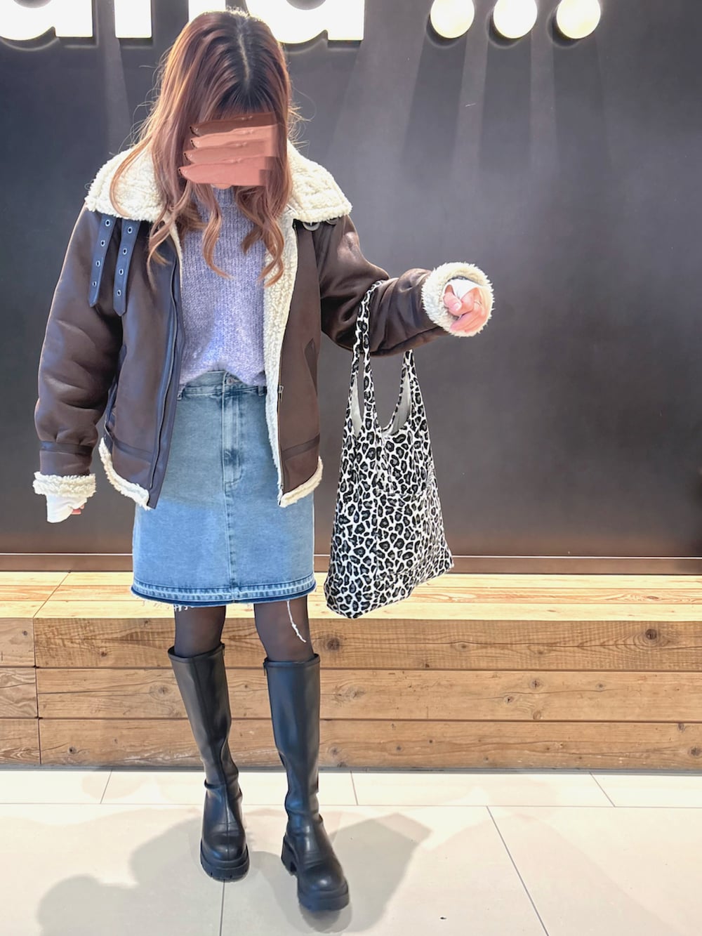 パープル系のニット/セーター、ホワイト系のTシャツ/カットソー、ブルー系のデニムスカートを着用したレディースの冬コーディネートの2枚目の写真