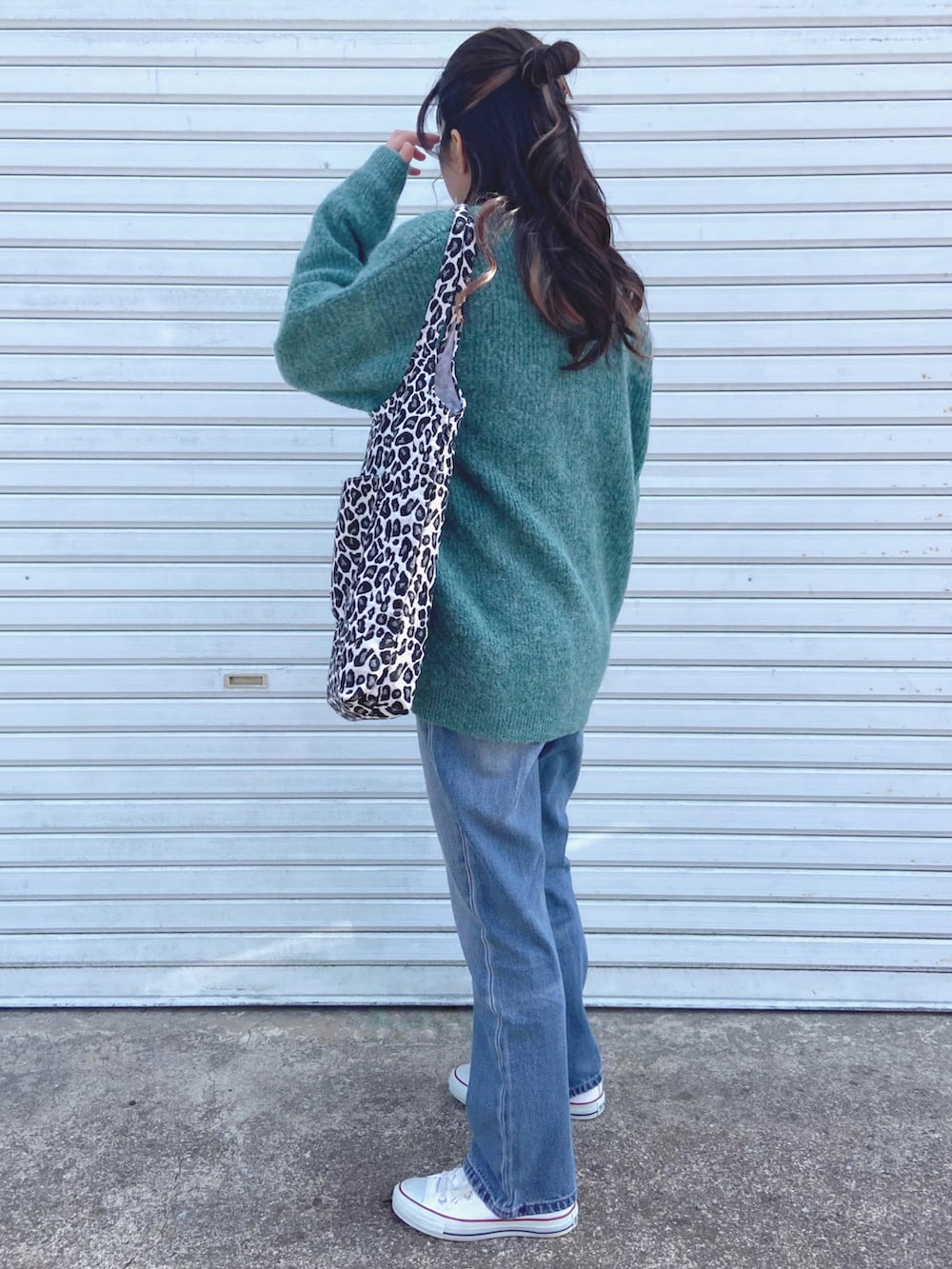 ホワイト系のTシャツ/カットソー、グリーン系のカーディガン/ボレロ、ブルー系のデニムパンツを着用したレディースの春コーディネートの2枚目の写真
