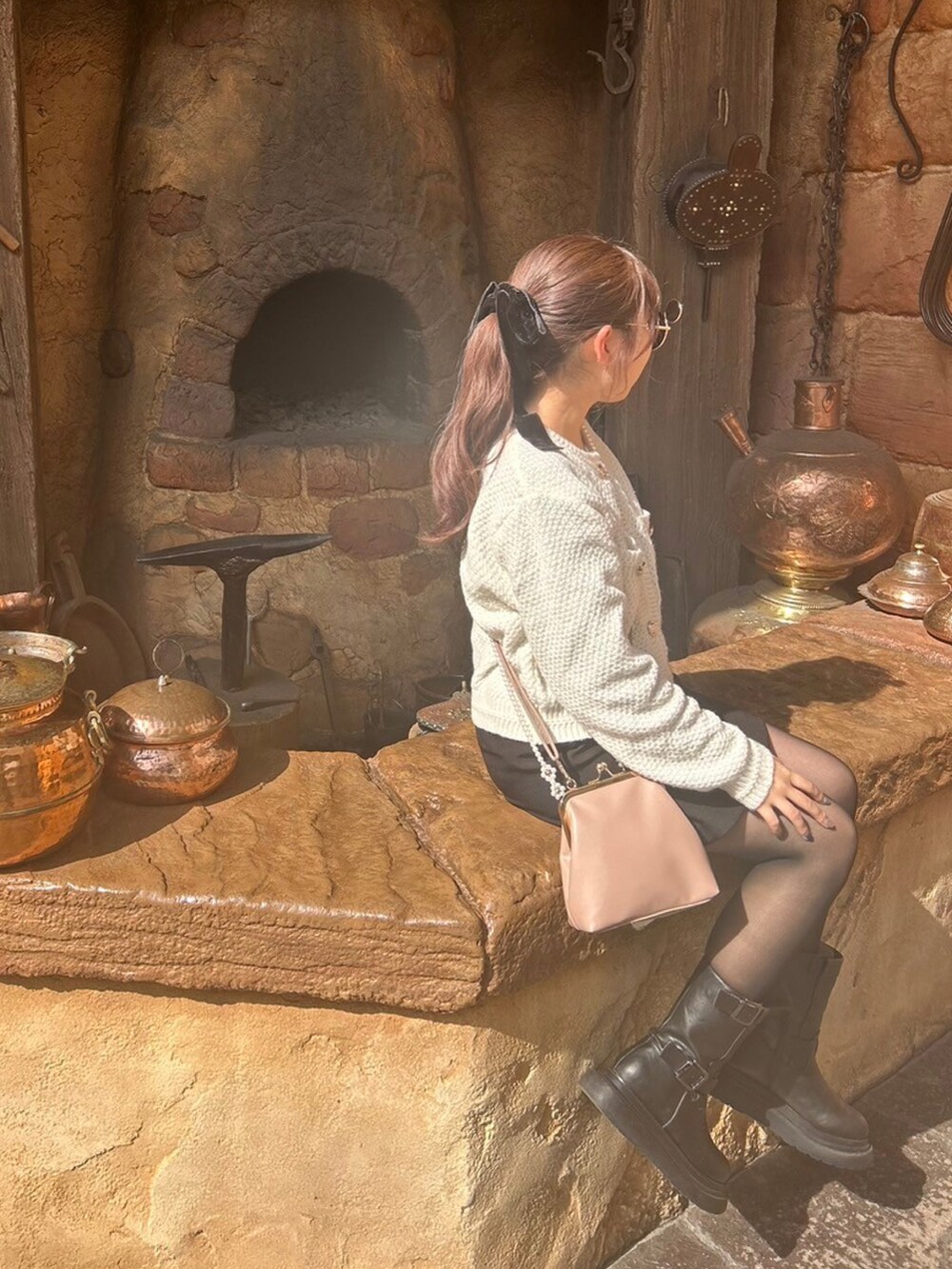 ホワイト系のカーディガン/ボレロ、ブラック系のスカート、ブラック系のブーツを着用したレディースの冬コーディネートの2枚目の写真