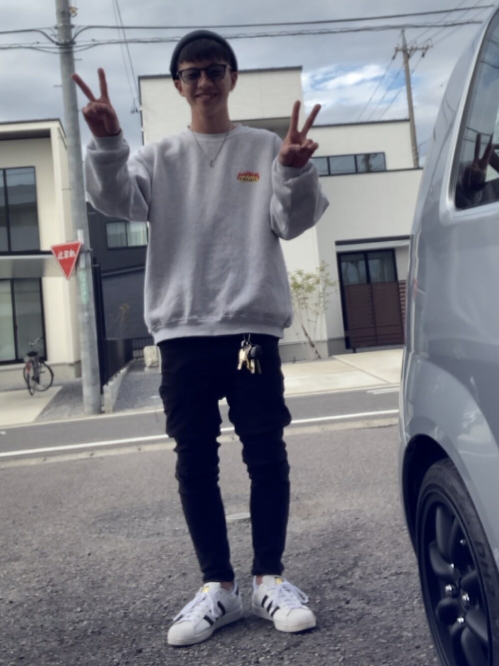 ブラック系のパンツ、ホワイト系のスニーカー、ブラック系のハットを着用したメンズの春コーディネートの2枚目の写真