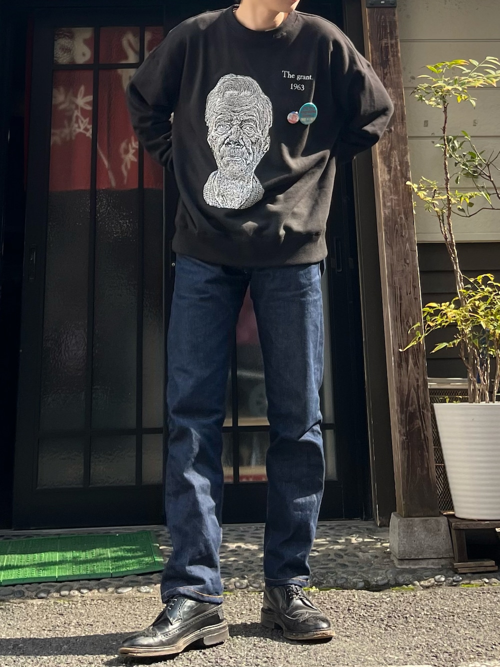 ブルー系のデニムパンツ、ブラック系のドレスシューズ、ブラック系のスウェットを着用したメンズの春コーディネートの4枚目の写真