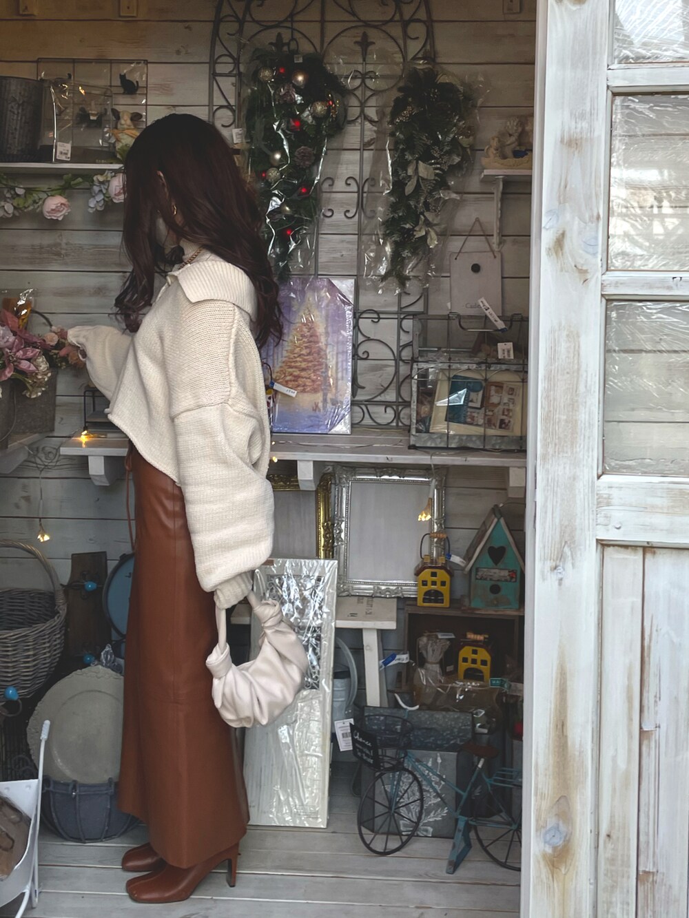 ベージュ系のニット/セーター、ブラウン系のスカートを着用したレディースの冬コーディネートの2枚目の写真