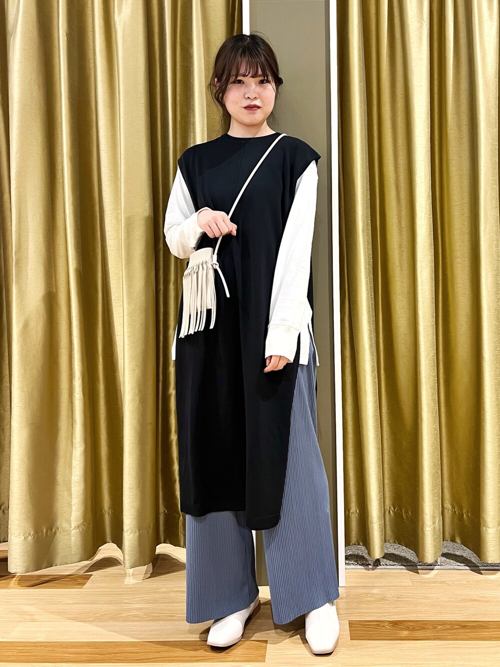 その他のブーツ、ブルー系のベスト、ブルー系のパンツを着用したレディースの冬コーディネートの2枚目の写真