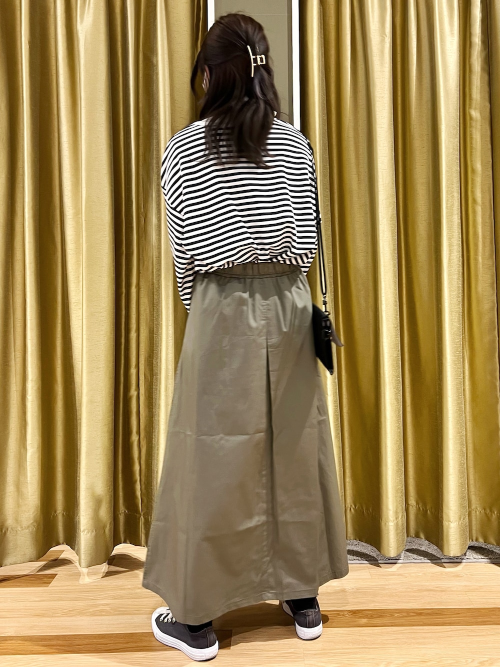 ブルー系のスニーカー、グリーン系のスカート、ブルー系のTシャツ/カットソーを着用したレディースの冬コーディネートの3枚目の写真