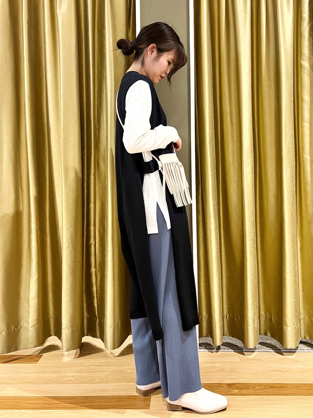 その他のブーツ、ブルー系のベスト、ブルー系のパンツを着用したレディースの冬コーディネートの3枚目の写真