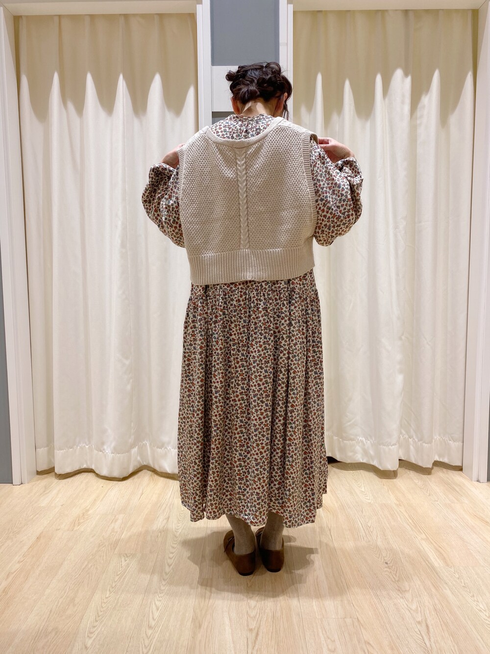 ベージュ系のワンピース、ブラウン系のその他シューズ、ベージュ系のベストを着用したレディースの冬コーディネートの3枚目の写真