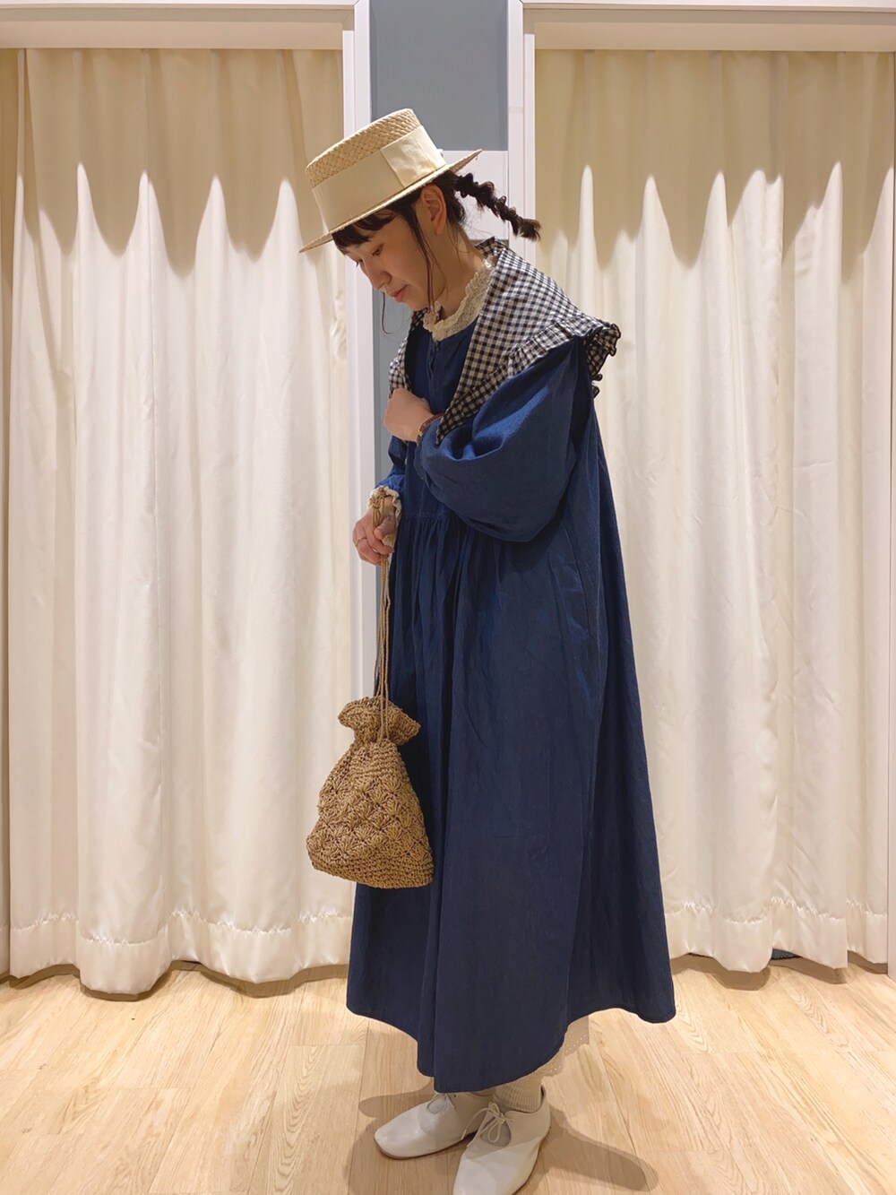 ブルー系のワンピース、ベージュ系のバッグ、ホワイト系のその他シューズを着用したレディースの春コーディネートの2枚目の写真