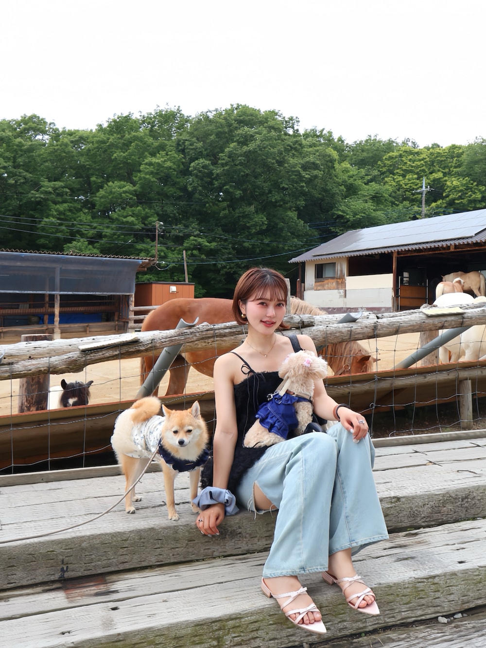 ブラック系のキャミソール、ブルー系のデニムパンツ、ピンク系のサンダルを着用したレディースの夏コーディネートの3枚目の写真