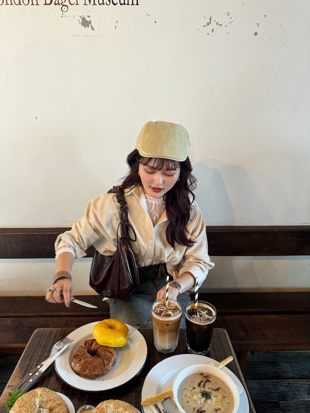 ベージュ系のシャツ/ブラウス、ブラウン系のハンドバッグ、ベージュ系のTシャツ/カットソーを着用したレディースの秋コーディネートの5枚目の写真