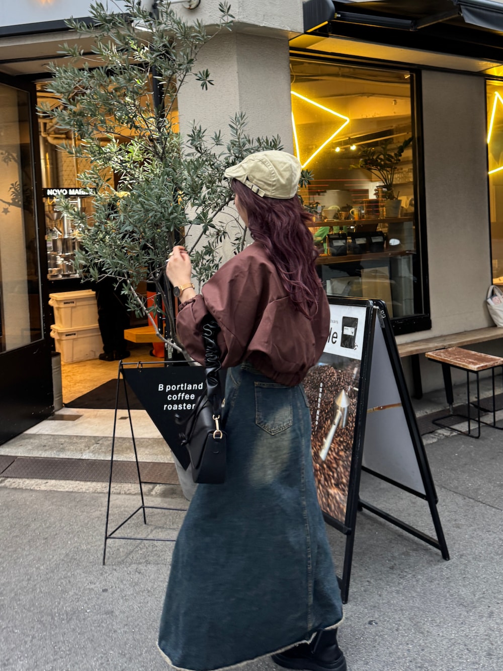 ブラウン系のハンドバッグ、ブラウン系のブルゾンを着用したレディースの秋コーディネートの2枚目の写真