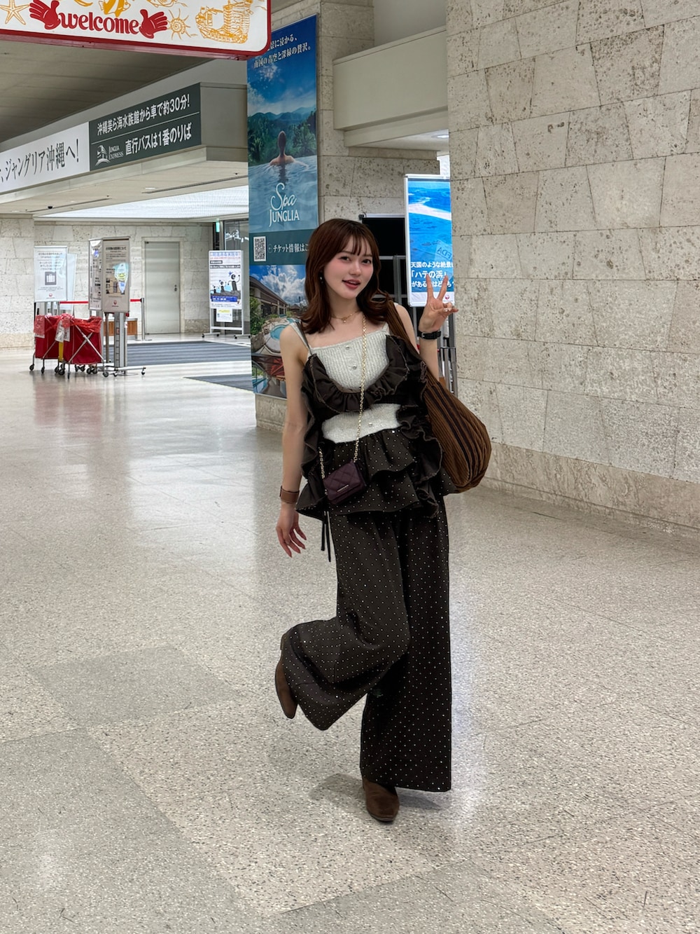 ブラウン系のその他パンツ、ブラウン系のブーツ、ホワイト系のカーディガン/ボレロを着用したレディースの冬コーディネートの2枚目の写真