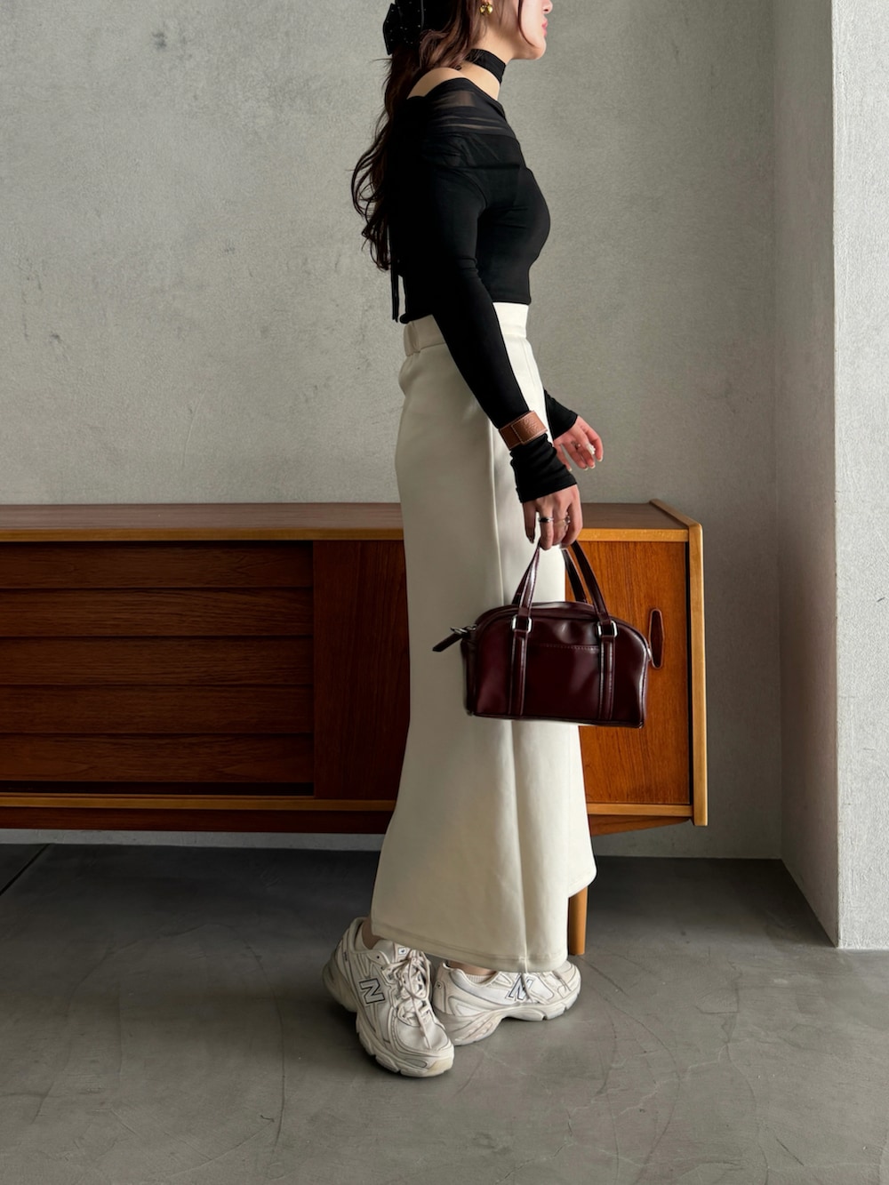 ブラック系のTシャツ/カットソー、ベージュ系のスニーカー、レッド系のショルダーバッグを着用したレディースの春コーディネートの3枚目の写真