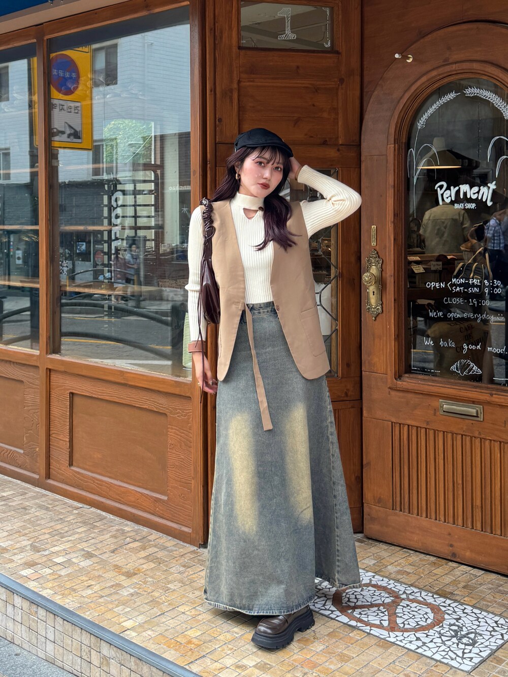 ブルー系のデニムスカート、ベージュ系のニット/セーター、ベージュ系のベストを着用したレディースの秋コーディネートの4枚目の写真