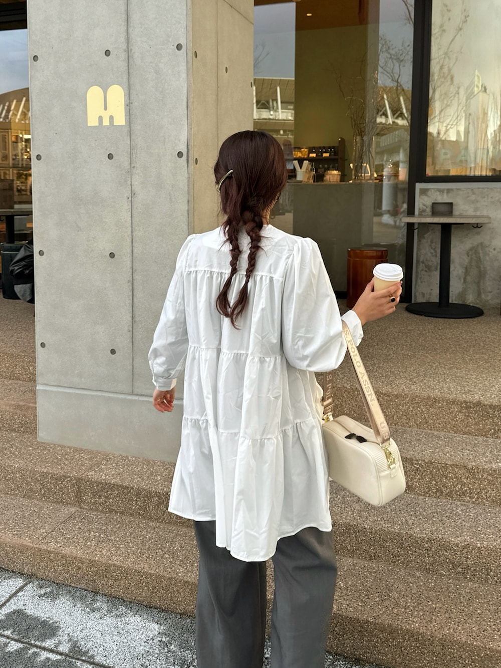 ホワイト系のワンピース、ピンク系のスニーカーを着用したレディースの冬コーディネートの3枚目の写真