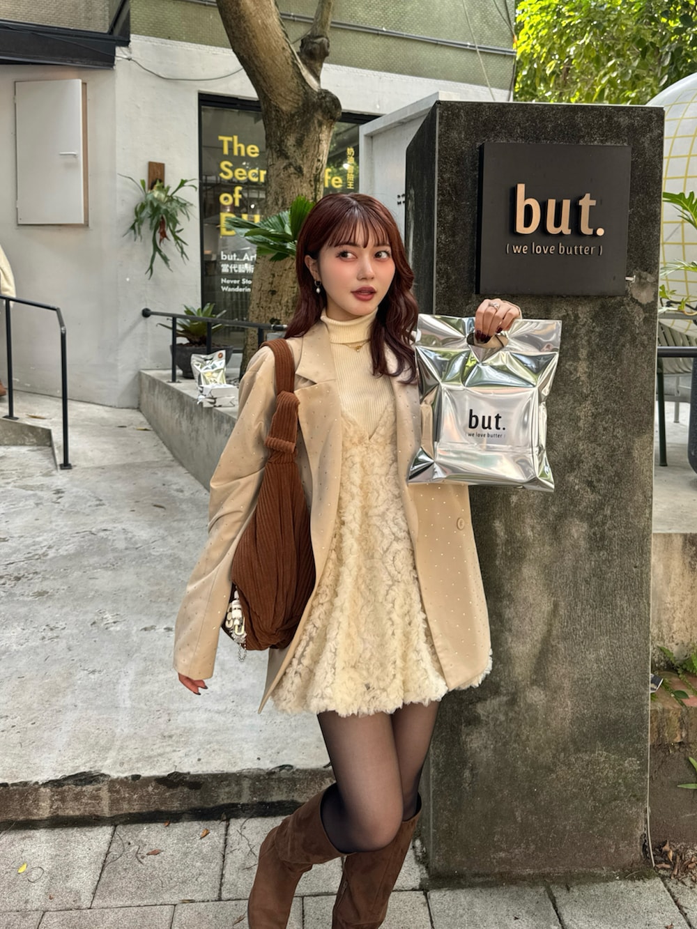 ベージュ系のテーラードジャケット、ブラウン系のブーツ、ブラック系のニット/セーターを着用したレディースの冬コーディネートの3枚目の写真