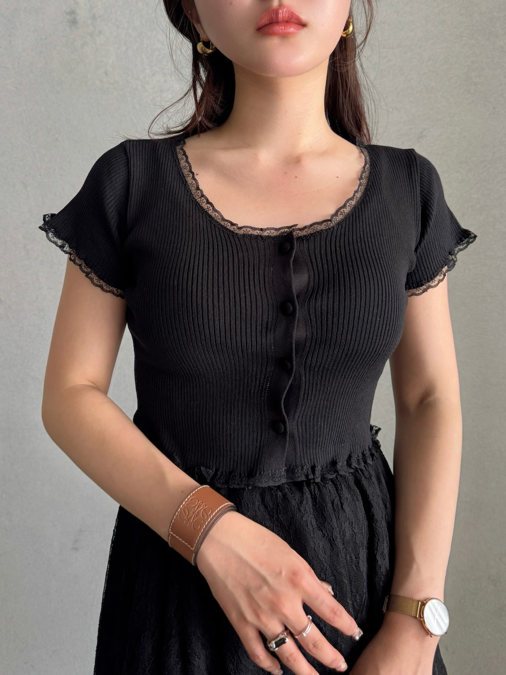 ブラウン系のハンドバッグ、ブラック系のスカート、ブルー系のデニムパンツを着用したレディースの春コーディネートの5枚目の写真