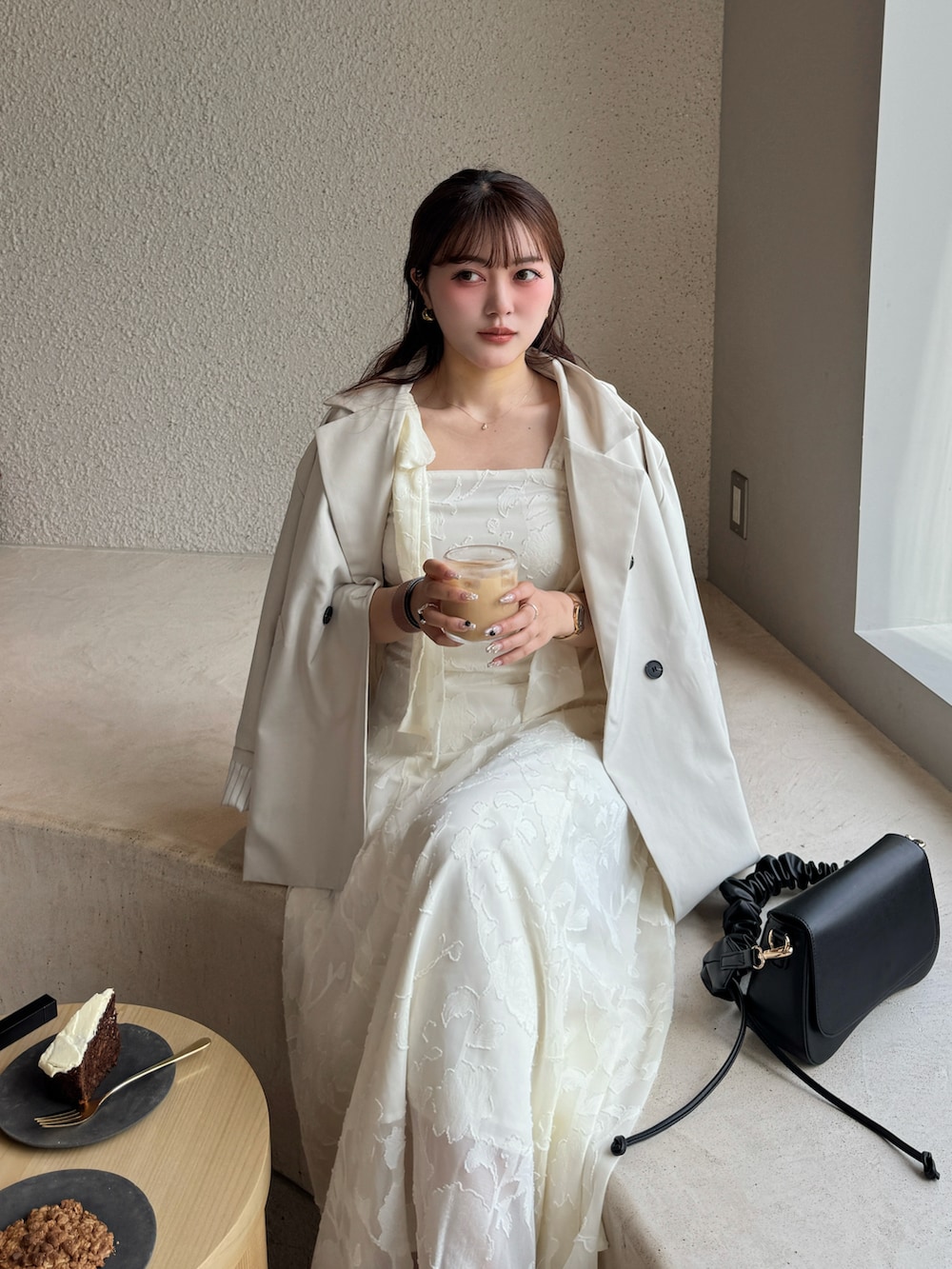 ホワイト系のワンピース、ブラック系のハンドバッグを着用したレディースの春コーディネートの5枚目の写真