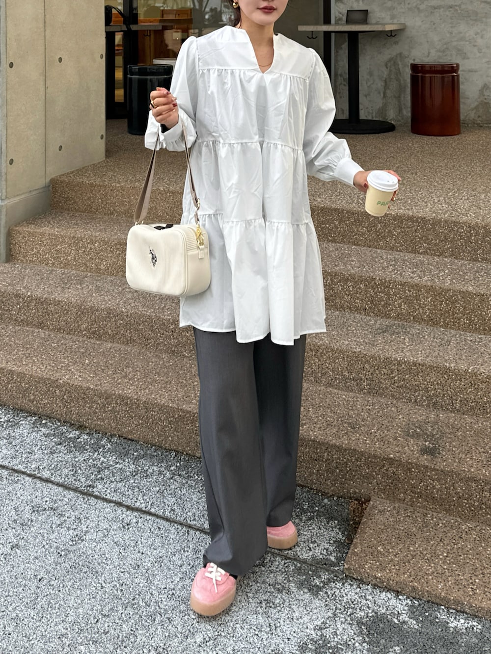 ホワイト系のワンピース、ピンク系のスニーカーを着用したレディースの冬コーディネートの2枚目の写真