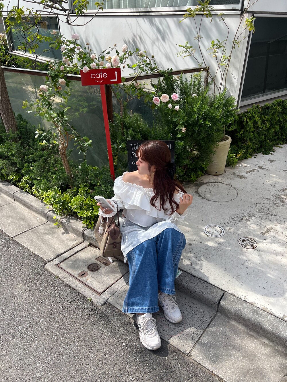 ブルー系のデニムパンツ、ホワイト系のシャツ/ブラウス、ホワイト系のスカートを着用したレディースの春コーディネートの2枚目の写真