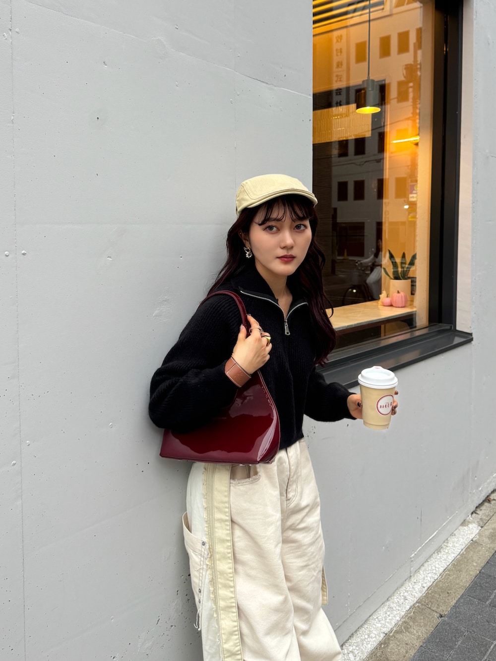 ブラック系のニット/セーター、ホワイト系のデニムパンツ、ベージュ系のスニーカーを着用したレディースの秋コーディネートの3枚目の写真