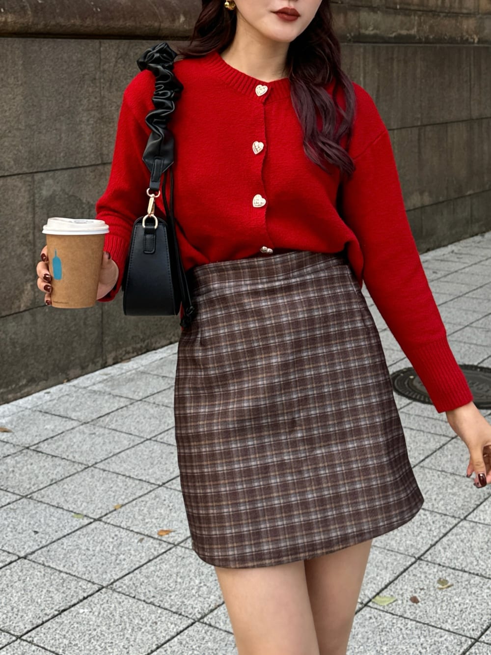 レッド系のニット/セーター、ブラウン系のスカートを着用したレディースの冬コーディネートの4枚目の写真