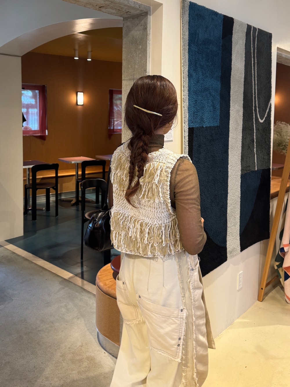 ブラック系のパンプス、ホワイト系のデニムパンツ、ホワイト系のベストを着用したレディースの夏コーディネートの5枚目の写真