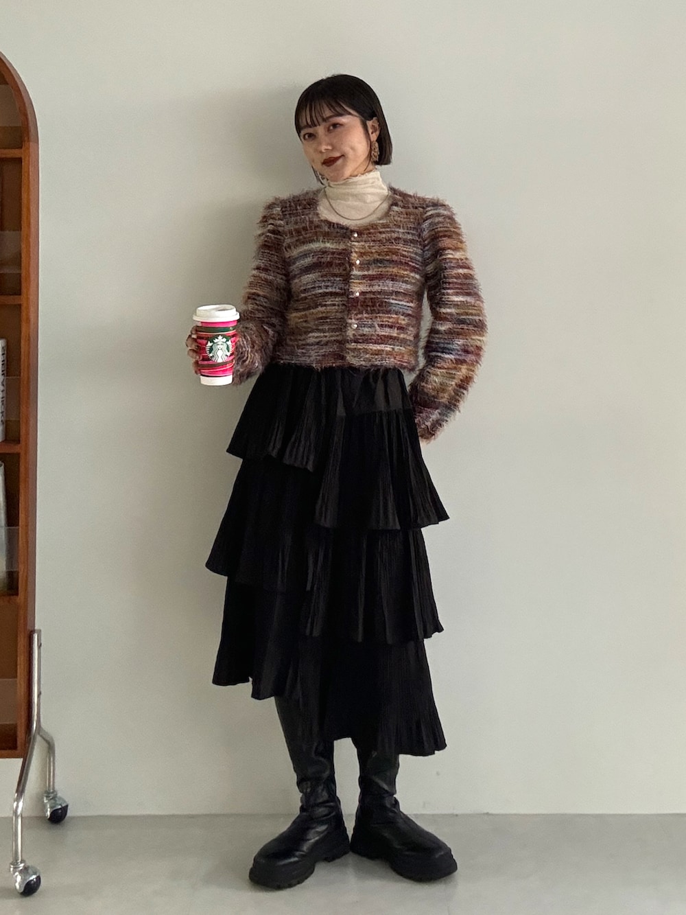 グレー系のカーディガン/ボレロ、ブラック系のブーツを着用したレディースの冬コーディネートの2枚目の写真